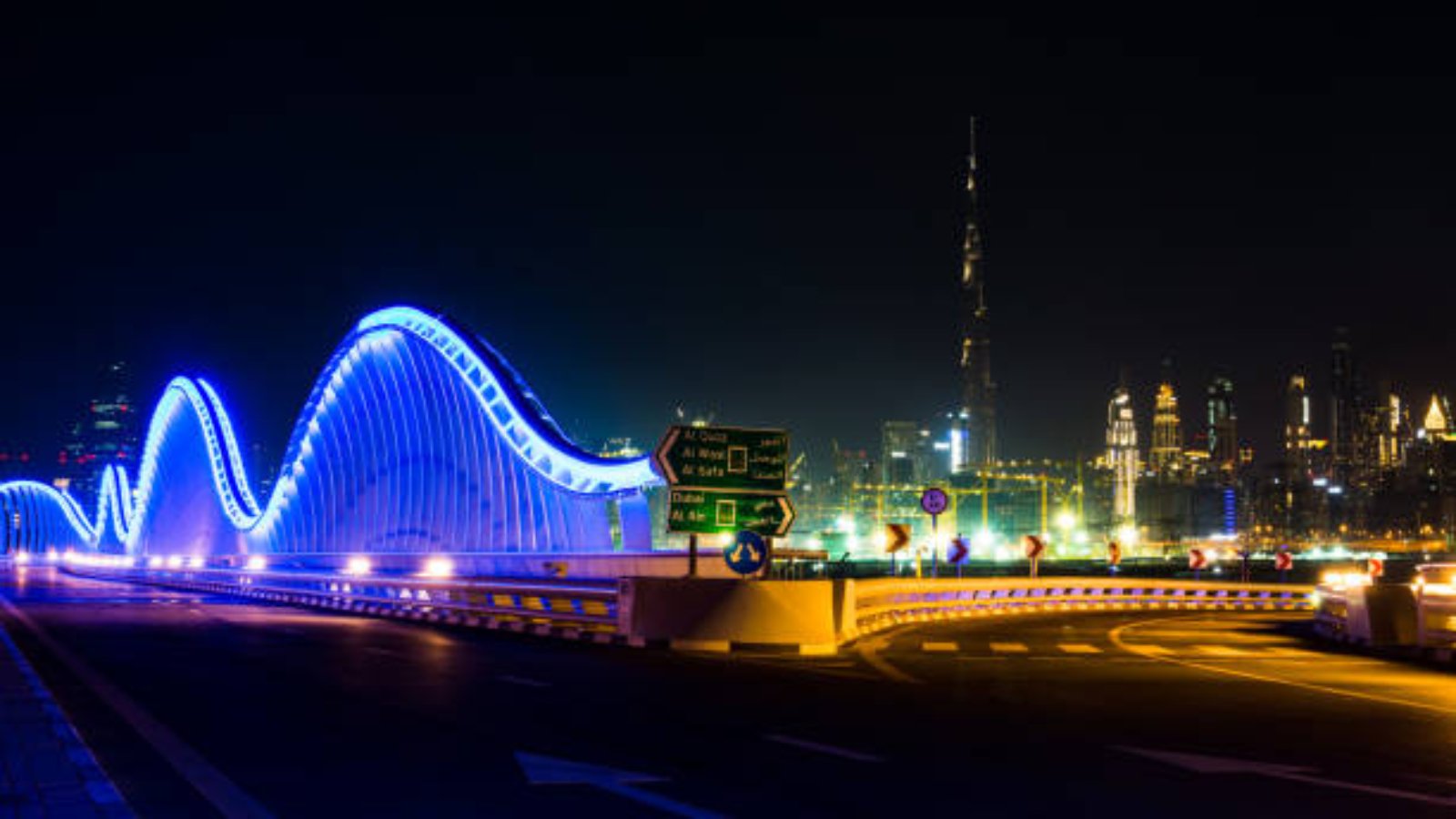 Modern Meydan bridge and Dubai cityscape at night